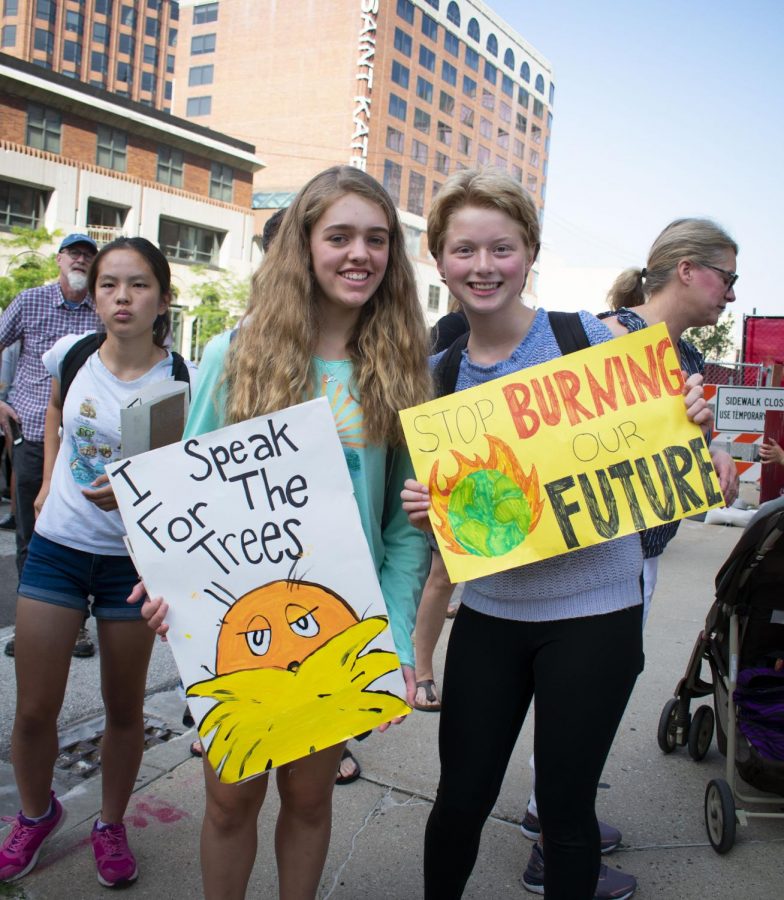 Sophie Diliberti and Juliet Peterka, sophomores, hold their signs at the Milwaukee Climate Strike. The two organized transportation so that Shorewood students could participate in the strike.