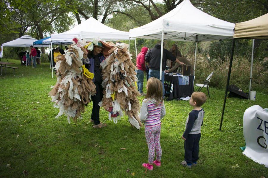Two kids listen to Sue Anderson as she explains about plastic waste. Anderson wore the costume to promote Plastic Free MKE at the Fish and Feather Festival.