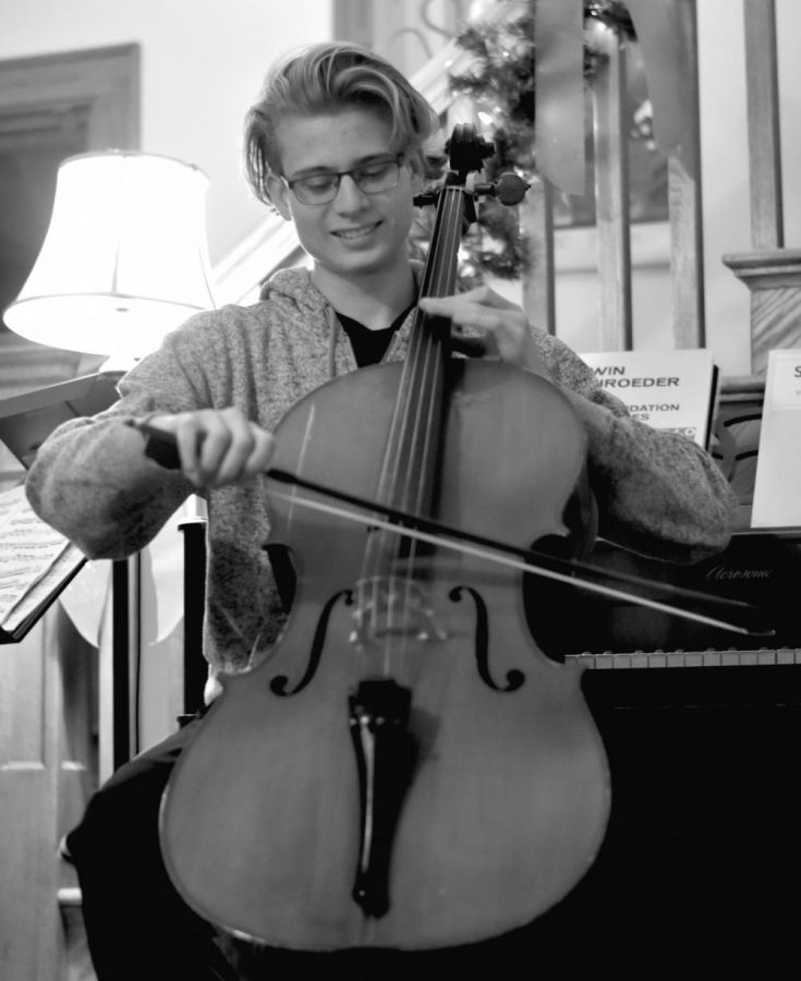 Nicholas Emanuelson, junior, plays his cello in his living room. His parents are both high school orchestra teachers and make sure he practices daily.