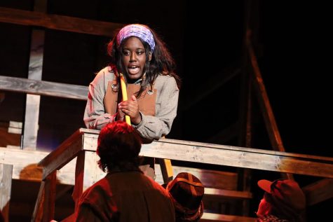 Nimya Harris sings in the spotlight during her character's solo number. Harris is praised for her performance as Penelope Pennywise, along with all of the acting in the show.