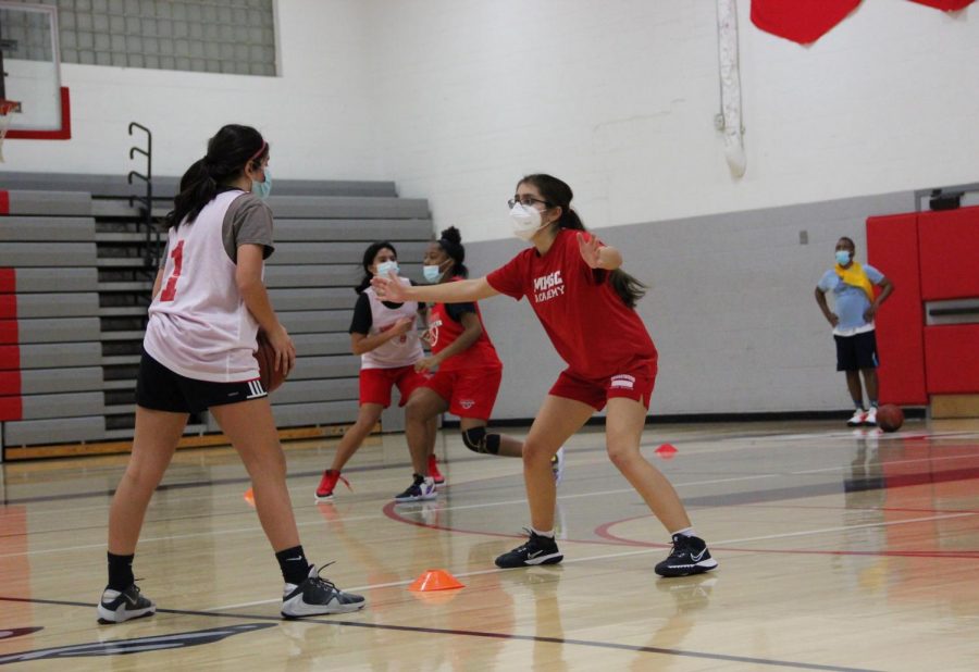 Nayana Menon, in white, holds the ball, while Sonia Bendre, in red, defends. In the back, Neveah Gomez, in white, goes up against Brooklyn Anderson, in red. 