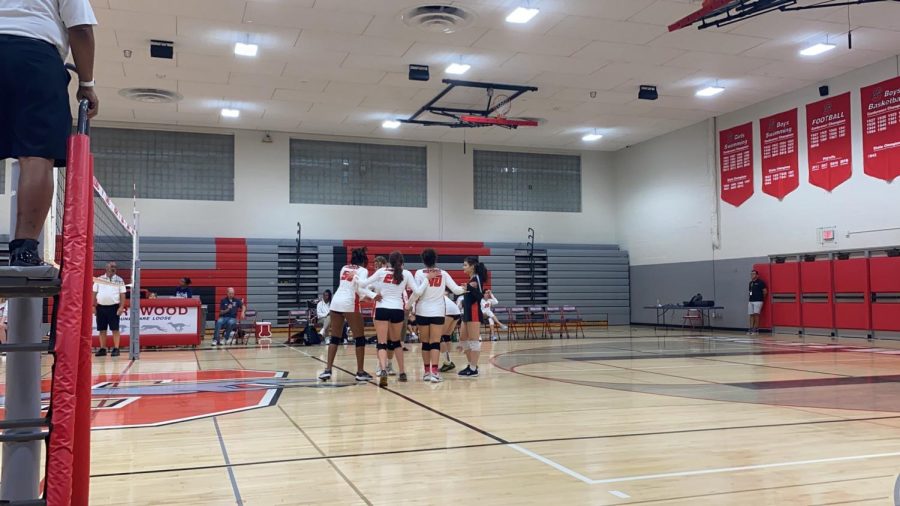 The girls varsity team huddling during their first game of the season, where they won 3-2.