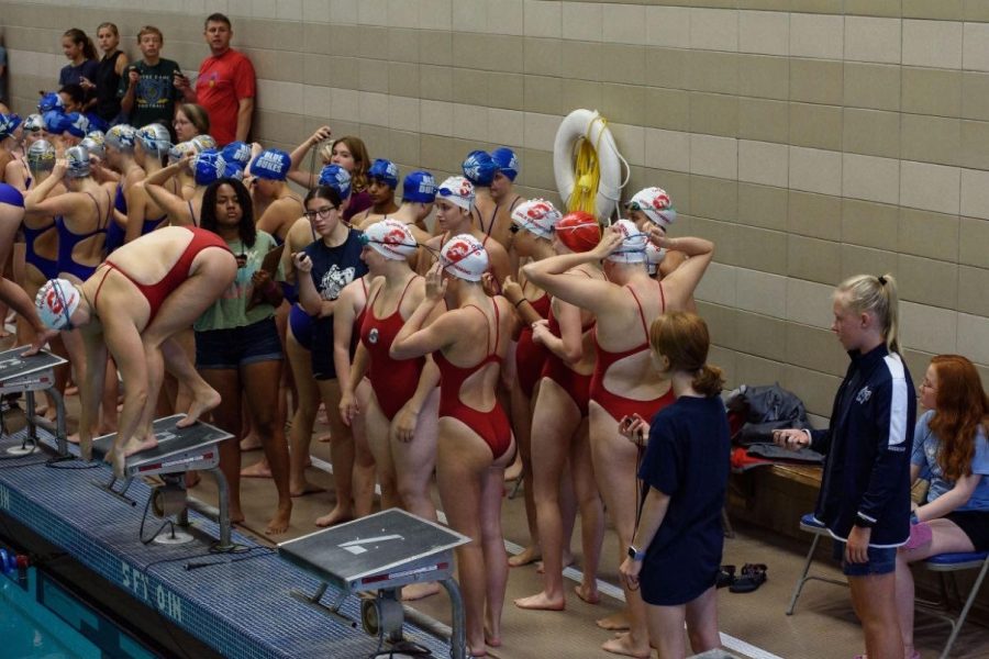 The girls swim team gathers at the starting blocks at the Nicolet sprints meet
