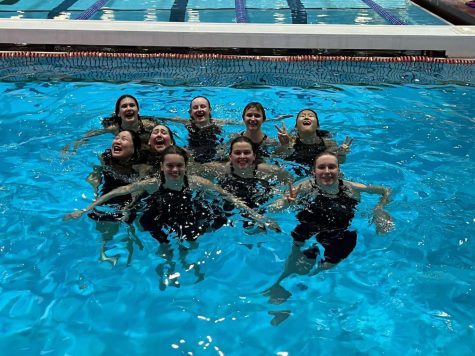 The girls swim team taking a group picture at the end of sectionals after having three teamates qualify for state championships in their individual races.